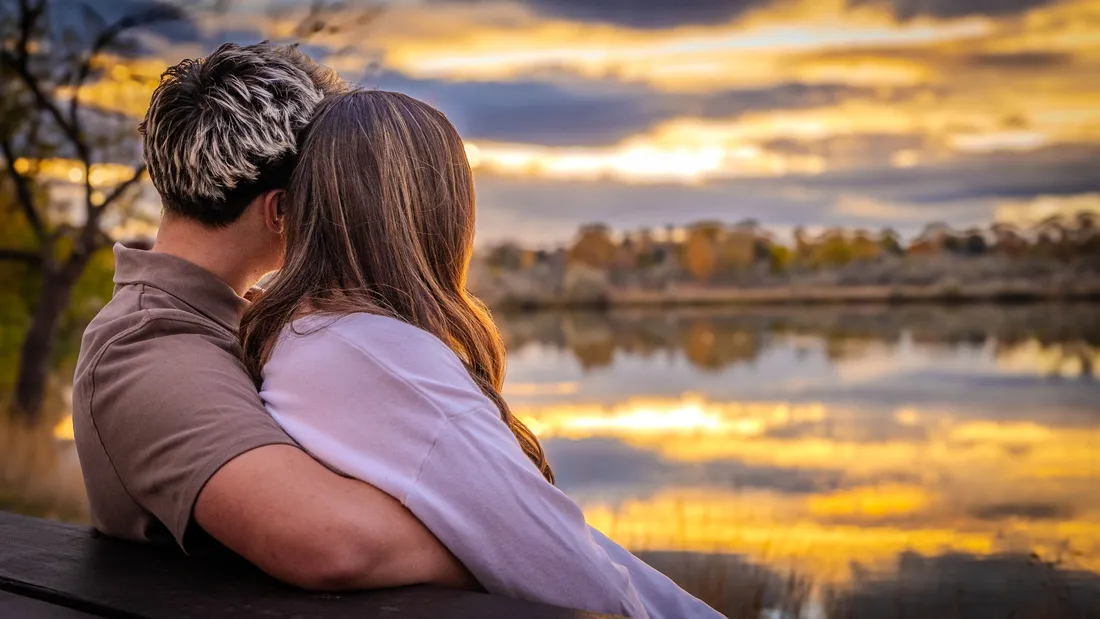 Couple watching the sunset over a lake